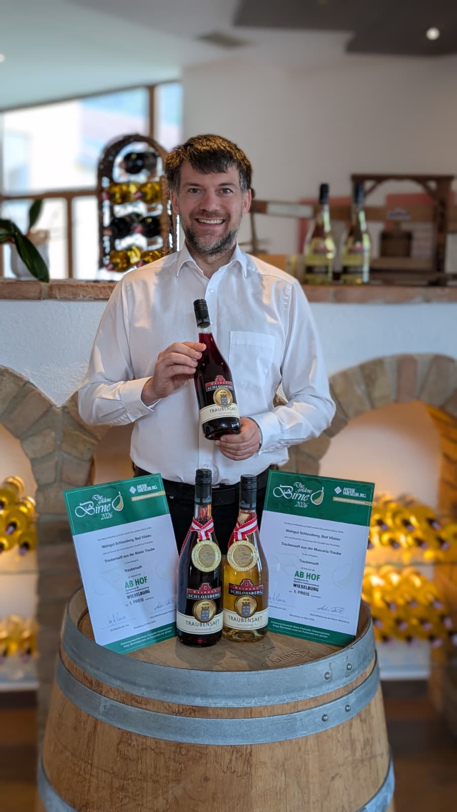Kellermeister Markus Wertek mit goldprämierten Traubensäften vor dem Gewölbekeller